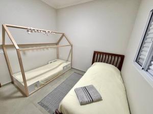 a small room with two beds and a window at Casa Lago da Dinda 3 in Espirito Santo Do Pinhal