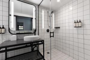 a white tiled bathroom with a sink and a mirror at The Guild Hotel, San Diego Downtown, a Tribute Portfolio Hotel in San Diego +116 photos