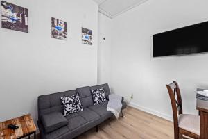 a living room with a couch and a flat screen tv at Apt Near Downtown Desk Wifi Tvs Games Pets in Houston