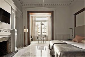 バルセロナにあるCasa Abamitaのベッドルーム(ベッド1台、暖炉、椅子付)