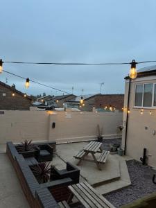 a patio with two benches and a picnic table at Valletta House Holiday Apartments in Skegness