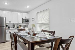 een keuken met een tafel met stoelen en een koelkast bij Downtown Heights Flat Games TVs WiFi Pets in Houston