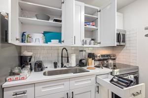 een keuken met witte kasten en een spoelbak bij Downtown Heights Flat Games TVs WiFi Pets in Houston +9 foto's