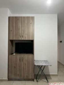 TV en un armario de madera en una habitación en Grandma's, en Sarandë
