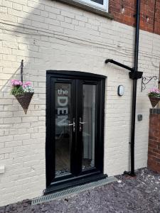 a black door on the side of a brick building at Valletta House Holiday Apartments in Skegness