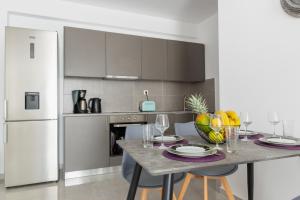 アルハンゲロスにあるKaterina family Apartmentのテーブルと椅子、冷蔵庫のあるキッチン +21枚の写真