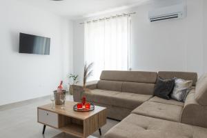 アルハンゲロスにあるKaterina family Apartmentのソファとコーヒーテーブルのあるリビングルーム