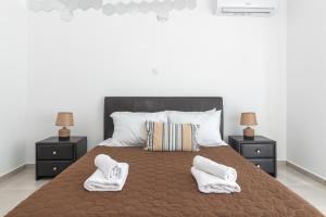 アルハンゲロスにあるKaterina family Apartmentのタオルが敷かれた大きなベッドのある寝室