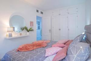 a bedroom with a bed with pillows on it at Alma's Dream Estepona in Estepona