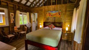 a bedroom with a bed in a wooden room at Toucan Hill Lodge in Bocas Town