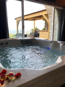 una vasca idromassaggio con vista su una casa di Nuit insolite avec jacuzzi privatif et piscine a La Roquette-sur-Var