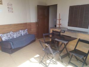 a living room with a bed and a table and chairs at Kitnet PRAIA GRANDE in Arraial do Cabo
