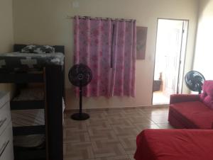 a room with a room with a bed and a fan at Kitnet PRAIA GRANDE in Arraial do Cabo