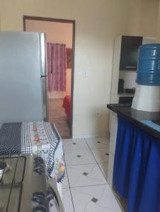 a kitchen with a refrigerator and a counter top at Kitnet PRAIA GRANDE in Arraial do Cabo