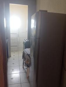 a large refrigerator in a room with a table at Kitnet PRAIA GRANDE in Arraial do Cabo