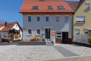 ein großes weißes Haus mit rotem Dach in der Unterkunft Lewe`s Ferienwohnungen in Dettingen an der Erms