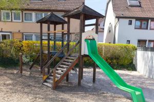 einen Spielplatz mit einer grünen Rutsche im Hof in der Unterkunft Lewe`s Ferienwohnungen in Dettingen an der Erms