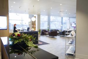 une femme assise au comptoir dans un salon dans l'établissement Original Sokos Hotel Vaakuna Hämeenlinna, à Hämeenlinna