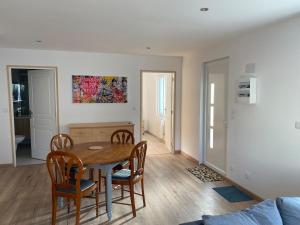 a dining room and living room with a table and chairs at Maison proche toutes commodités in Chinon