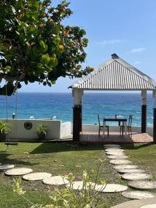 un tavolo e delle sedie sotto un gazebo vicino all'oceano di The Sea Cliff Hotel Resort & Spa a Port Antonio