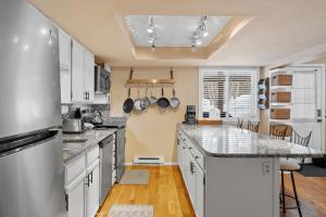 a kitchen with white cabinets and granite counter tops at Creekside Condos #A7 in Frisco +22 photos