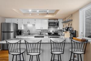 a kitchen with a counter with four bar stools at Creekside Condos #A7 in Frisco