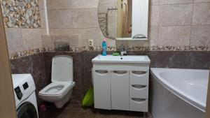 a bathroom with a sink and a toilet and a mirror at Чорноморськ Квартира на парковій in Chornomorsk +1 photo