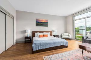 アッシュビルにあるRiver Row Suitesのベッドと大きな窓のある寝室