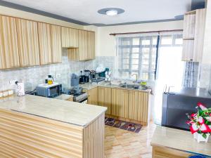 a kitchen with wooden cabinets and a counter top at The Kulta Spot Executive Living in Thika