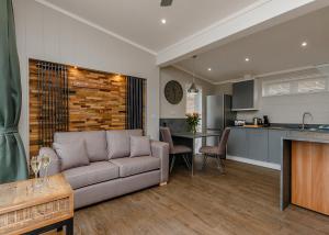 a living room with a couch and a kitchen at Cheddar Woods Resort And Spa in Cheddar