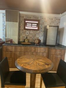 a kitchen with a wooden table with two chairs at Recanto do Ziu in Santa Teresa