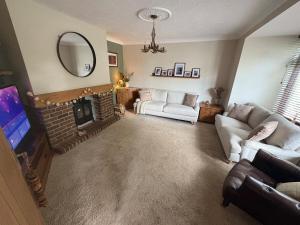 a living room with a fireplace and a mirror at Fairfield Large 4 Bed Log Fire in Isham