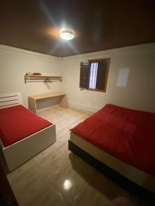 a small room with two beds and a window at Recanto do Ziu in Santa Teresa