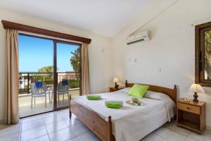 a bedroom with a large bed and a balcony at Villa Heracles by Villa Plus in Peyia