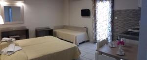 una camera d'albergo con due letti e una televisione di Pallada Hotel ad Agia Galini