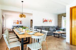 a dining room and living room with a table and chairs at Villa Tres Arcos by Villa Plus in Cala en Blanes