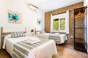a bedroom with two beds and a window at Villa Tres Arcos by Villa Plus in Cala en Blanes +29 photos