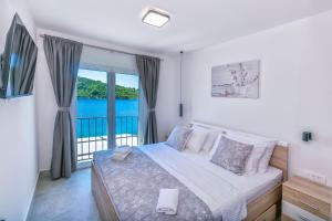 a bedroom with a bed with a view of the water at House Paval in Brnistrova +35 photos