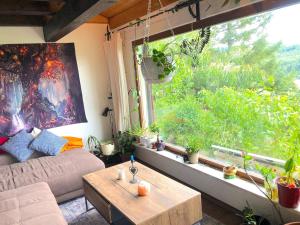 a living room with a couch and a table and a window at Ferienhaus, Schöntal-Winzenhofenn in Winzenhofen
