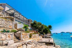 a building with stairs next to the water at House Paval in Brnistrova