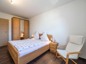 un dormitorio con una cama y una silla en Traumhaftes Feriendomizil in der Vulkaneifel, en Ellscheid