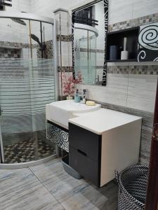 a bathroom with a white sink and a shower at Villa Azalea in Grand Baie