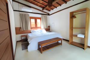 a bedroom with a white bed and a mirror at Vida Cajuína Maraú in Marau