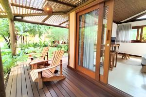 a patio with chairs and a table on a deck at Vida Cajuína Maraú in Marau +135 photos