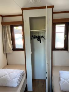 a bedroom with two beds and a closet at Stacaravanverhuur KR00N chalet BB-5 in Workum