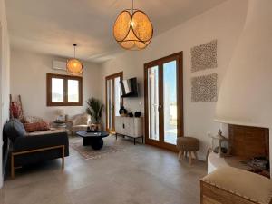 a living room with a couch and a table at Elysian Sea View New Golden Beach Piso Livadi in Chrissi Akti