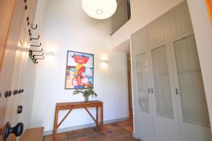 un pasillo con una mesa y una pintura en la pared en Casa del Angel by SIERRA VIVA, en Los Marines