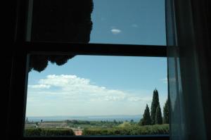 a window with a view of a field and trees at Agriturismo Tenuta la Pergola in Bardolino