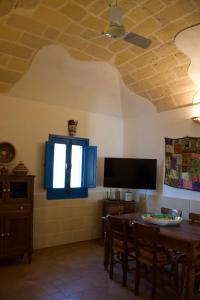 a dining room with a table and a tv on a ceiling at Casa Garibaldi , Piazza Sant'anna Favignana in Favignana