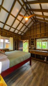 una camera con un letto in una stanza con pareti in legno di Toucan Hill Lodge a Bocas del Toro
